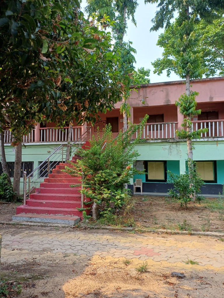 Outdoor red staircase and two-storey classroom building on the school campus